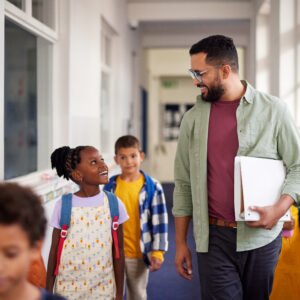 Professeur qui parle à ses élèves en marchant dans le corridor
